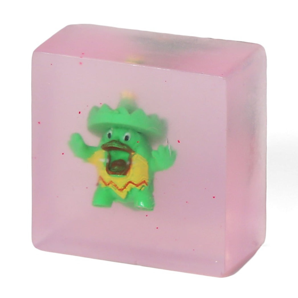 Clear light pink soap with a green toy inside.